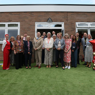 Nursery staff and officials at an outdoor event.