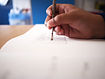 Hand using a brush to paint a textured square on paper