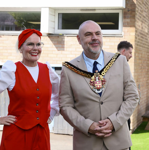 Woman in red and man with mayoral chain at nursery
