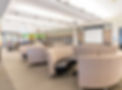 Teen section of the library featuring curved patterned seating, an &lsquo;Ask Here&rsquo; help desk, bookshelves, and a blank projector screen.