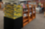 Library scene with two wooden bookshelves partially filled with books, and a display blocked off with yellow &lsquo;Under Construction&rsquo; tape for Halloween.