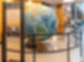 Large globe encased in a metal rail indoors, with an informational sign titled &lsquo;The McMillen Globe.&rsquo;