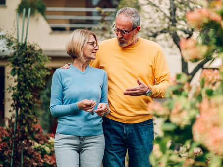Mature couple walking outside a house