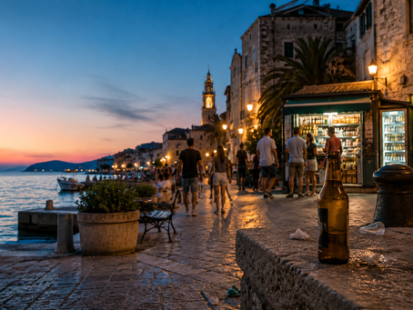 Večernja šetnica u mediteranskom turističkom gradu, s trgovinom u pozadini i praznom bocom pive na kamenoj ogradi, kao ilustracija teme zabrane prodaje alkohola i upravljanja javnim prostorom u sezoni.