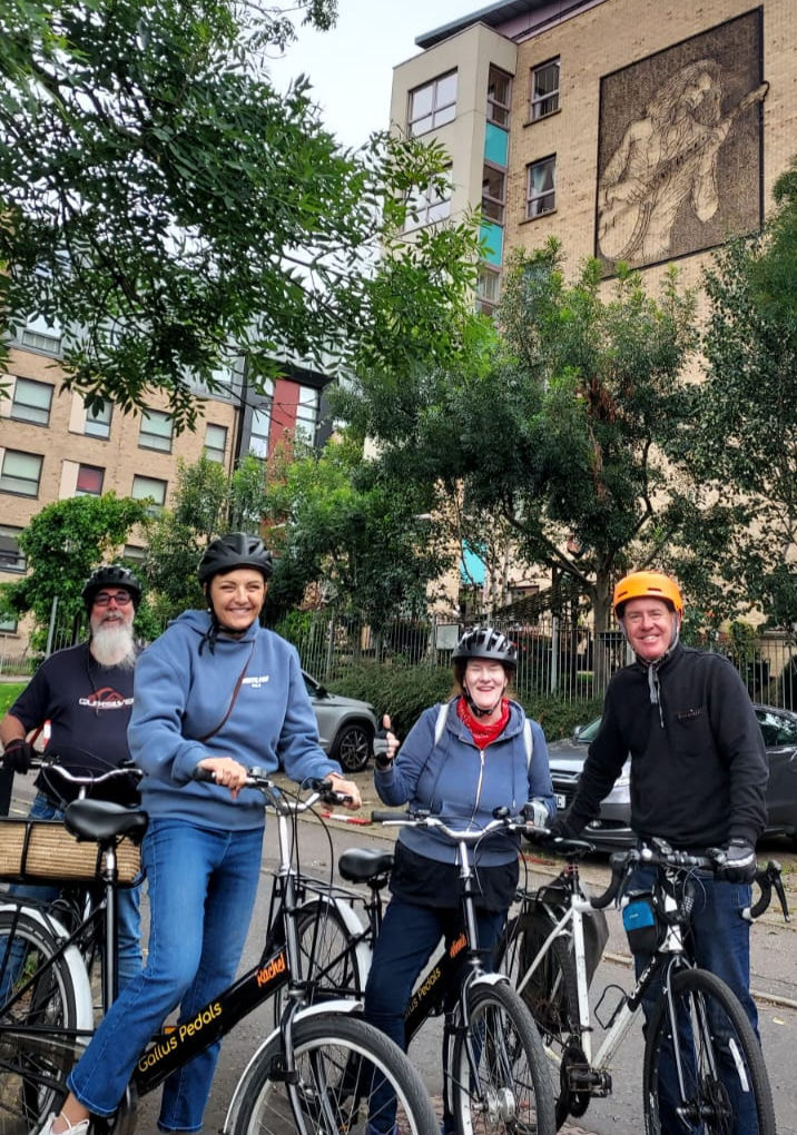 Our Glasgow Bike Tour guests by one of Billy's murals in Anderston