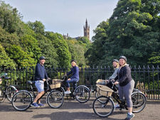 A group of friends on a bridge with the University of Glasgow in the background.