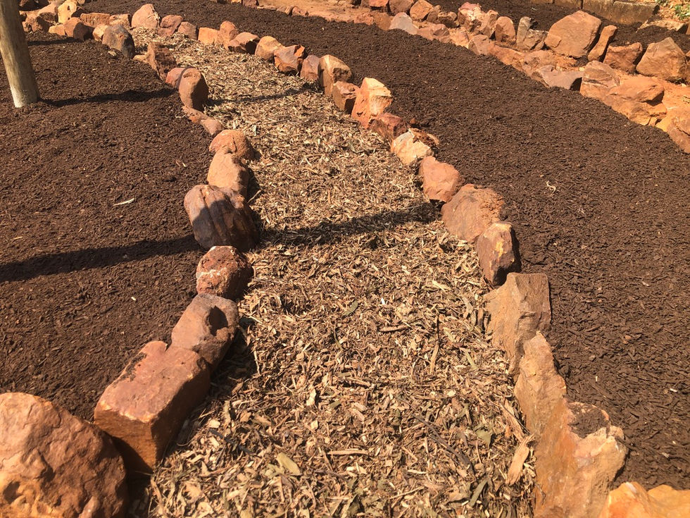Installing natural stone pathways within the circular garden layout.