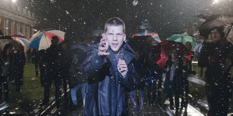 A person in a dark coat reaches towards the camera amidst falling rain or snow. A crowd with colorful umbrellas stands in a dimly lit street.