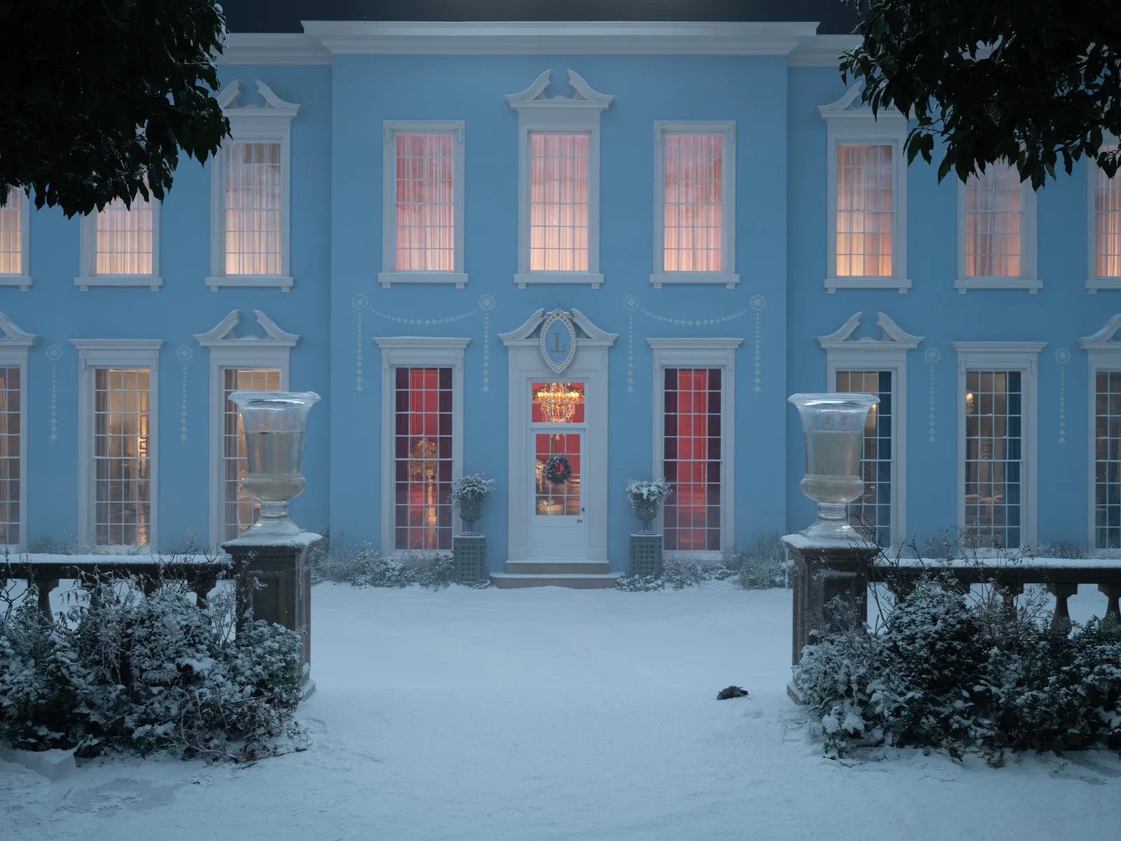 a house in the snow framed by its opening gate