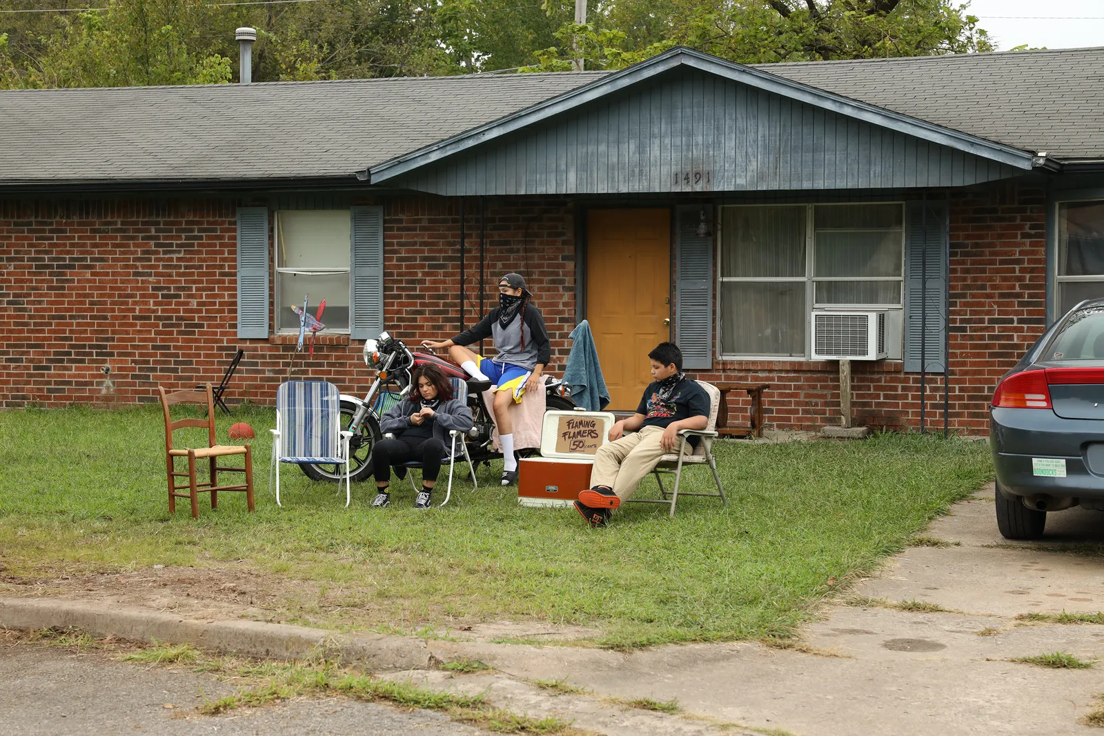 Three kids sitting on lawn