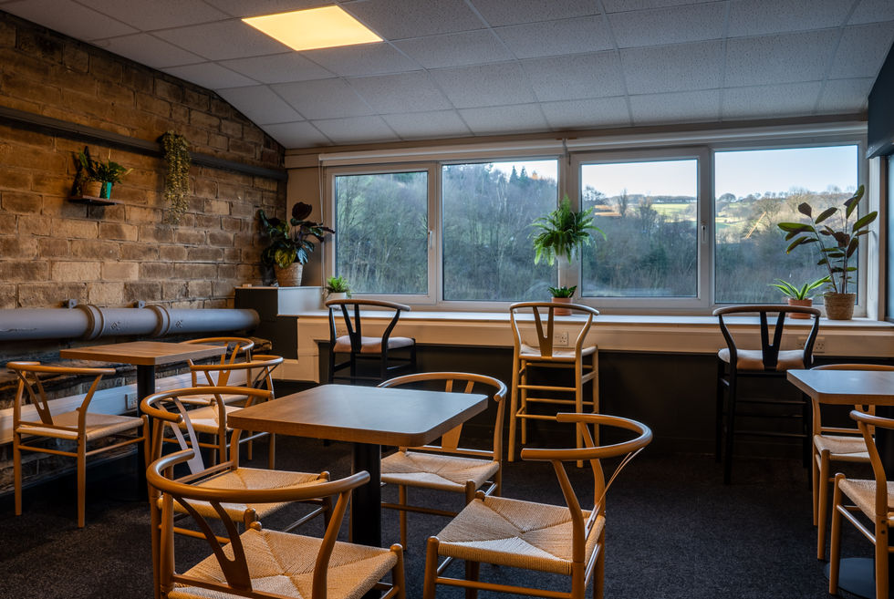 Cozy room with wooden chairs and large windows.