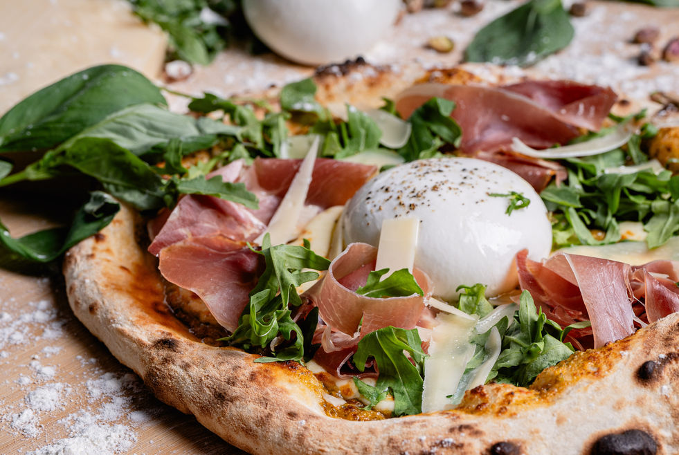a pizza with ham and mozzarella on top of it
