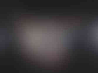 People in dim hall with a colorful digital art display on back wall. Geometric patterns and circles. Image Vojtěch=Veškrna