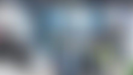 A crowd at a conference hall looking at technology displays and talking in groups