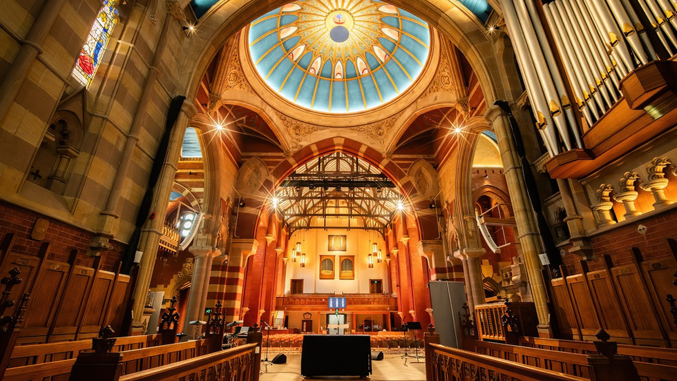 The interior of an ornate church with a high blue dome
