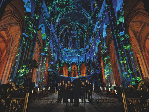 A dark blue and green projection on the roof of a cathedral