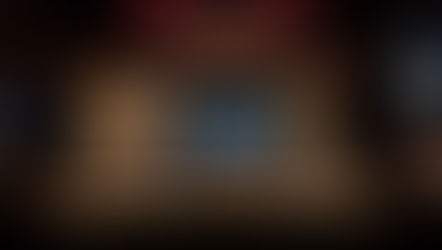 A sound console at the back of an empty auditorium with a glowing stage