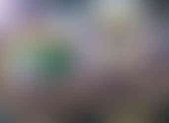 A packed show floor with signage and large art on the walls and ceiling