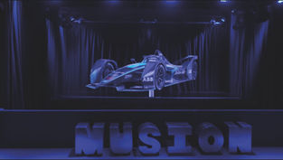 A purple race car floating on a stage with letters in front spelling "Musion"