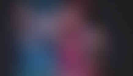 A band standing on a stage with large screens hanging above them