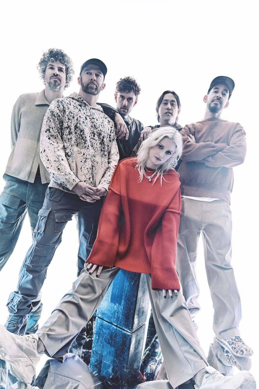 A band standing as a group and looking at a low camera