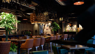 A dimly-lit restaurant with tables and chairs