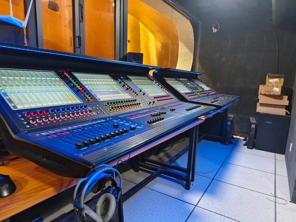 A long mixing desk from DiGiCo Quantum with a window above