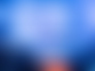 A packed concert hall with a T-shaped staged lined with dancers in pink and blue lighting