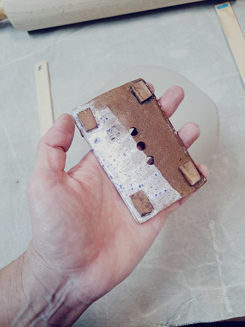 Underside of two-tone ceramic soap dish showing four raised feet