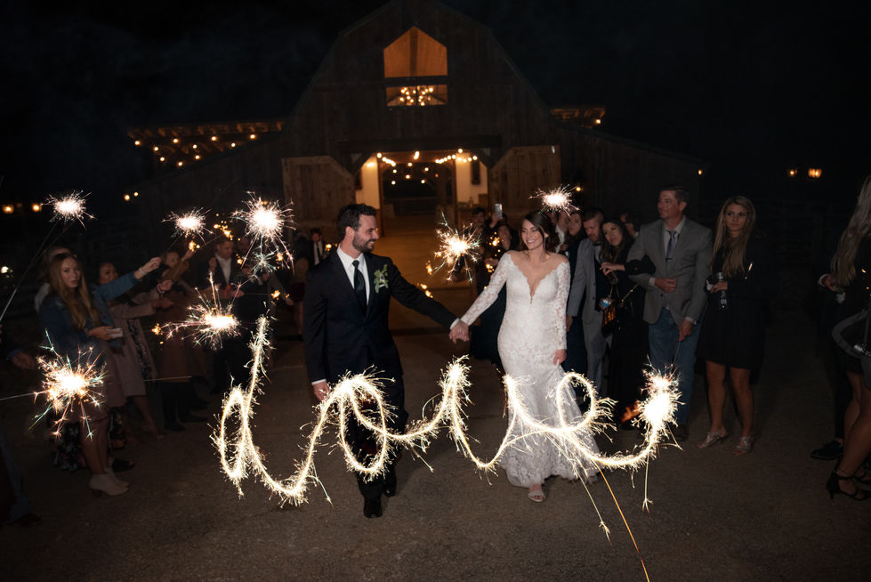 Sparklers spelling LOVE as the couple walks past at their wedding send-off