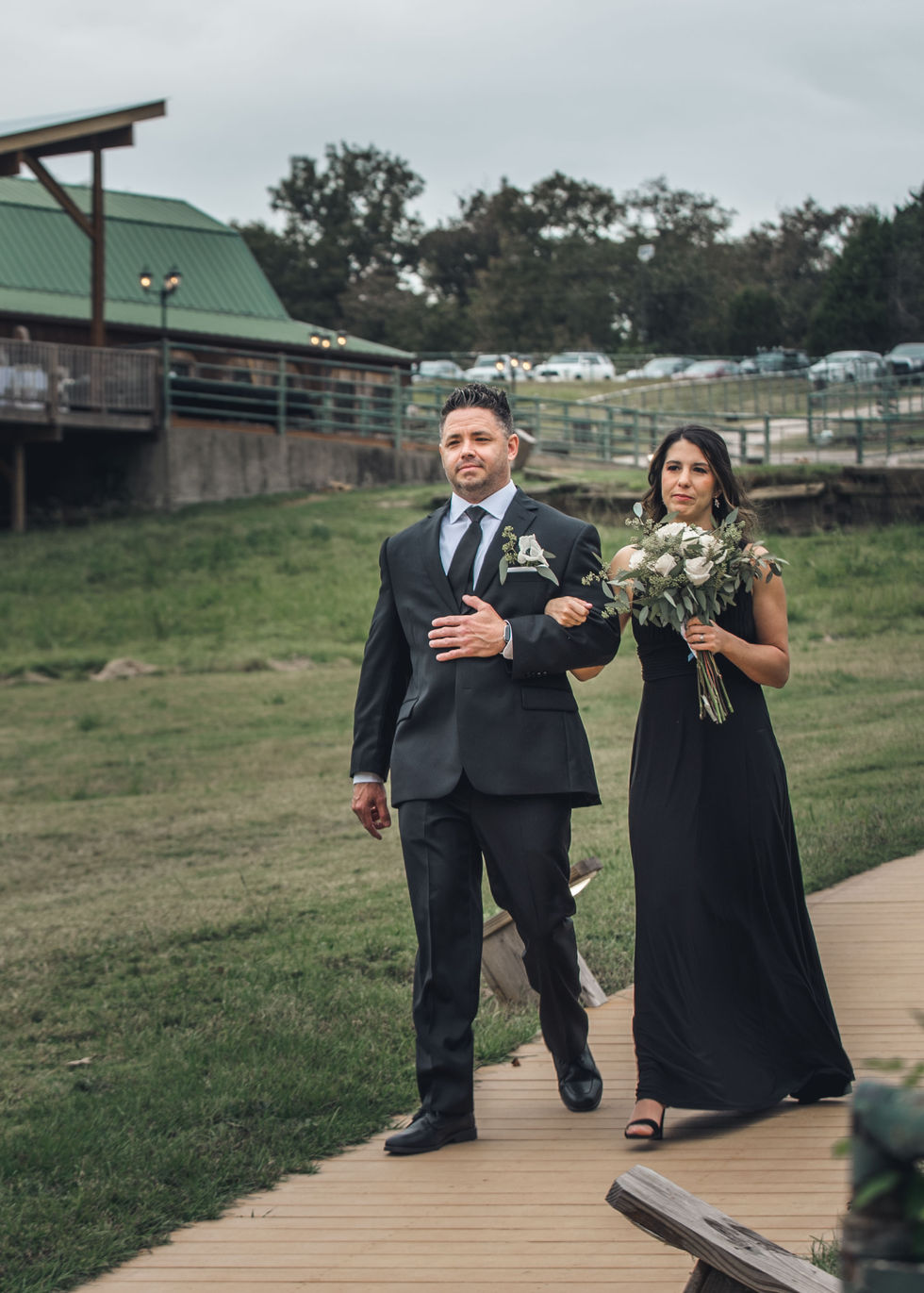 Groomsman and bridesmaid walking toward the ceremony site