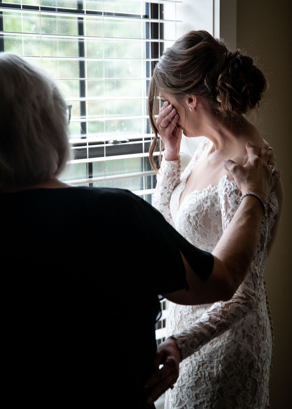 Bride sharing an emotional moment by the window before the ceremony