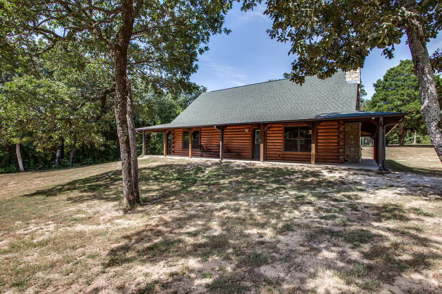 Luxury hunting lodge exterior with stone and wood construction at Cedar Cove Ranch