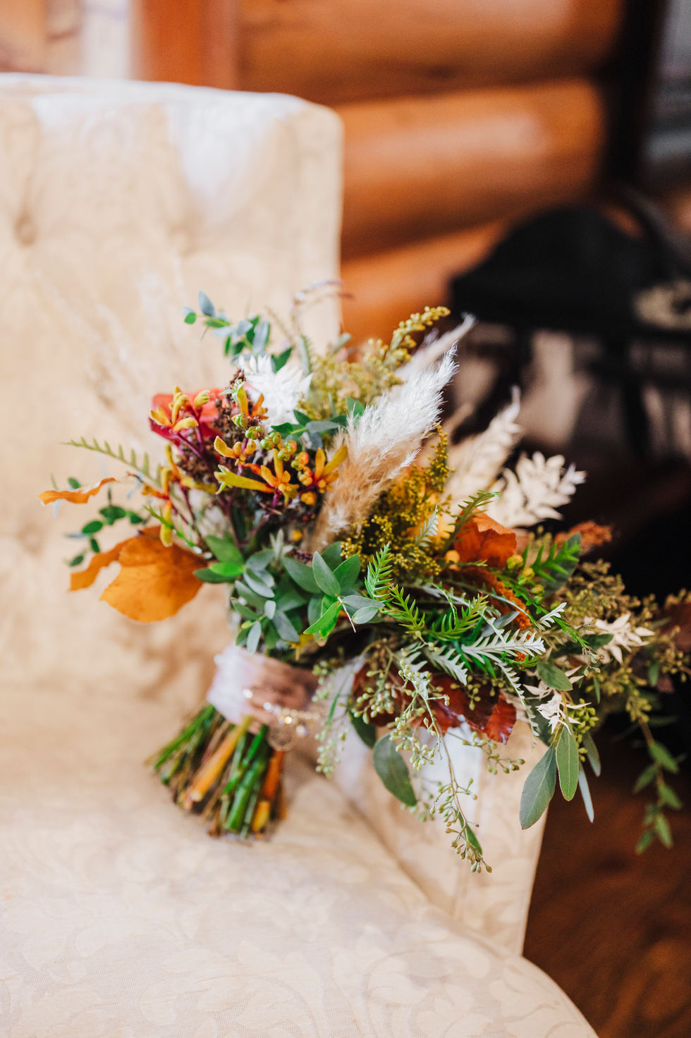 Orange floral bouquet resting on a rustic wooden surface