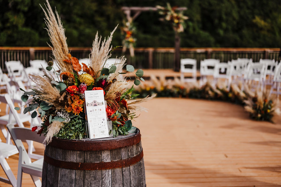Whiskey barrel floral arrangement with ceremony program card