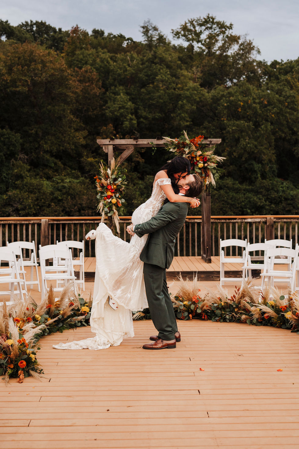 Bride and groom dancing near the floral ceremony arch