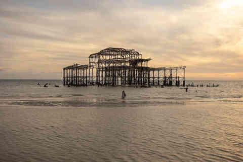 Woman looking at Brighton West Pier from the beach — fine art print by Alessandro Intini