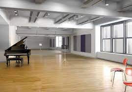 Large room, with a grand piano and music stand. Chairs also feature.