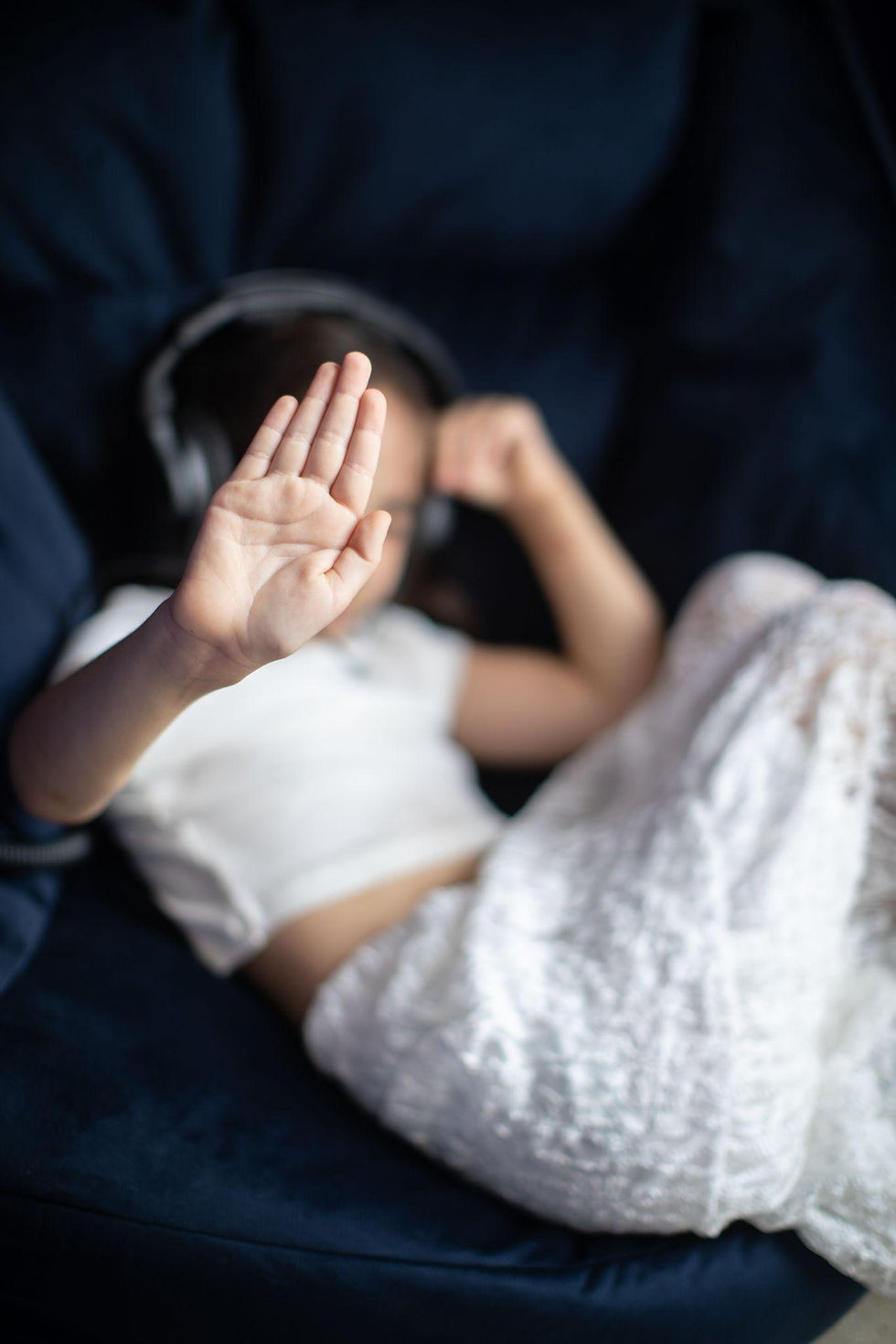 Girl with headphones holding up her hand in a stop gesture
