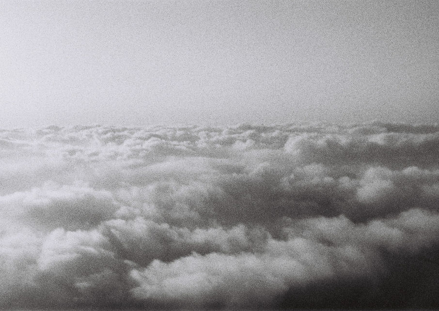 Black-and-white analogue photo of a vast sea of clouds taken from above, evoking a serene and dreamlike atmosphere.