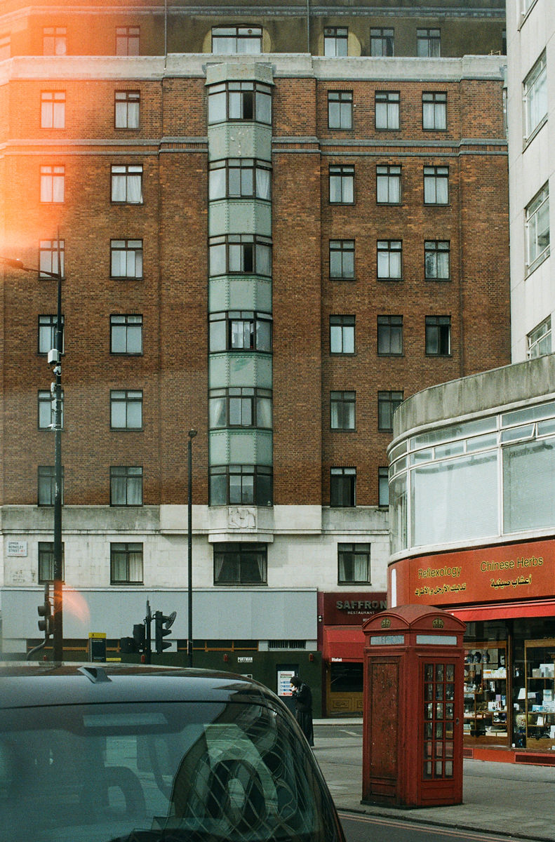 Red phone booth and brick building London street photography