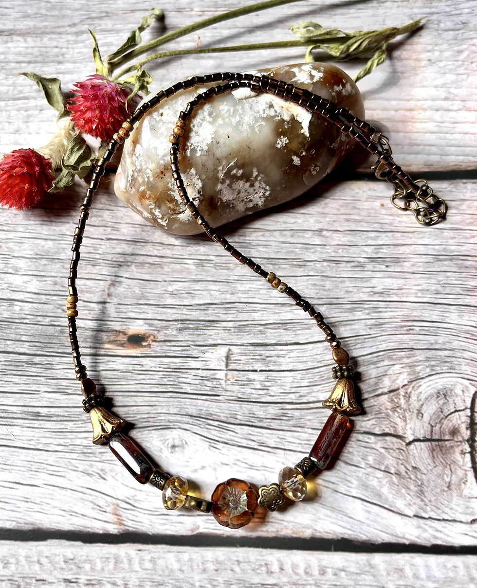 Miniature : Elegant necklace with beads, flower charm, and details on a wooden surface.