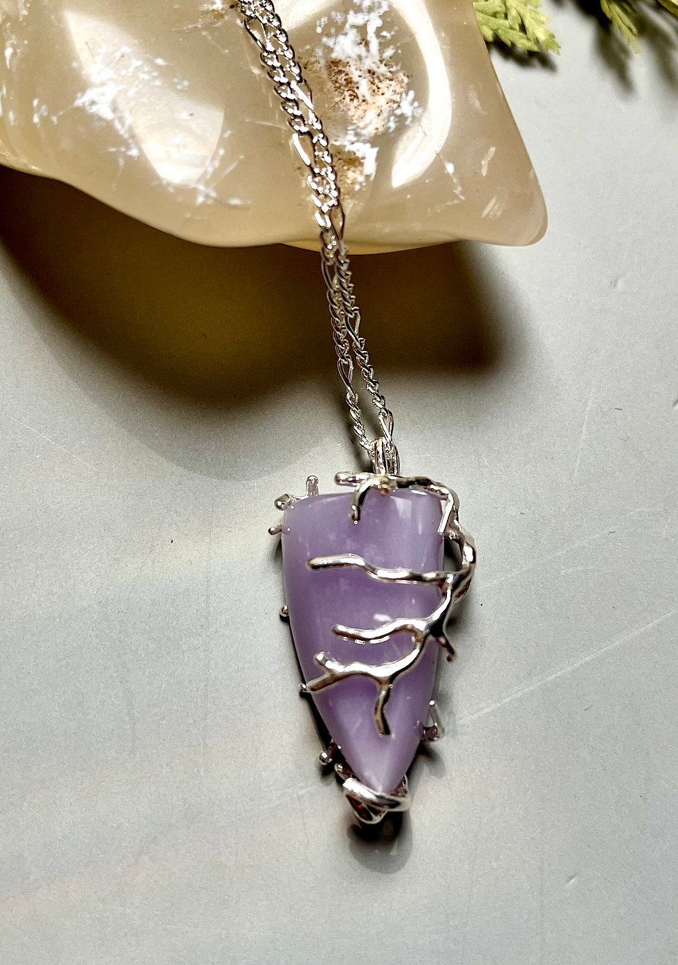 Miniatura: Silver chain holds a purple Yttrium Fluorite Pendant Necklace, held by a hand.