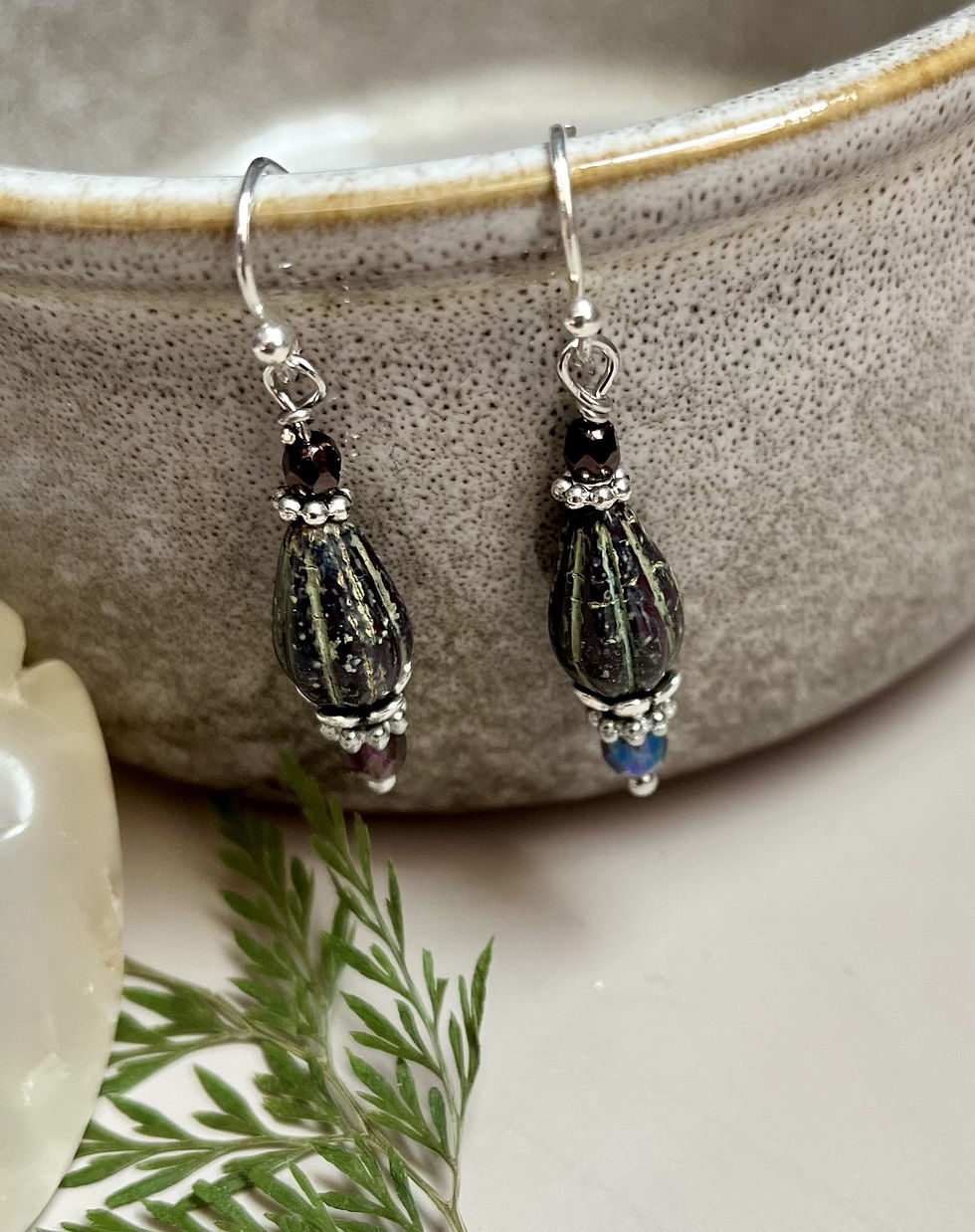 Miniatura: Close-up of dangling earrings with black, olive, and silver beads