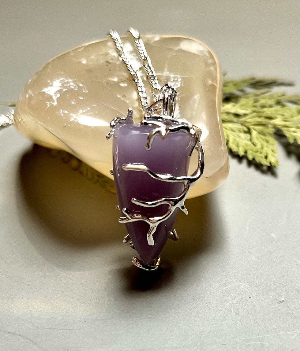 Miniatura: Purple Yttrium Fluorite Pendant Necklace, silver chain, resting on a beige stone.