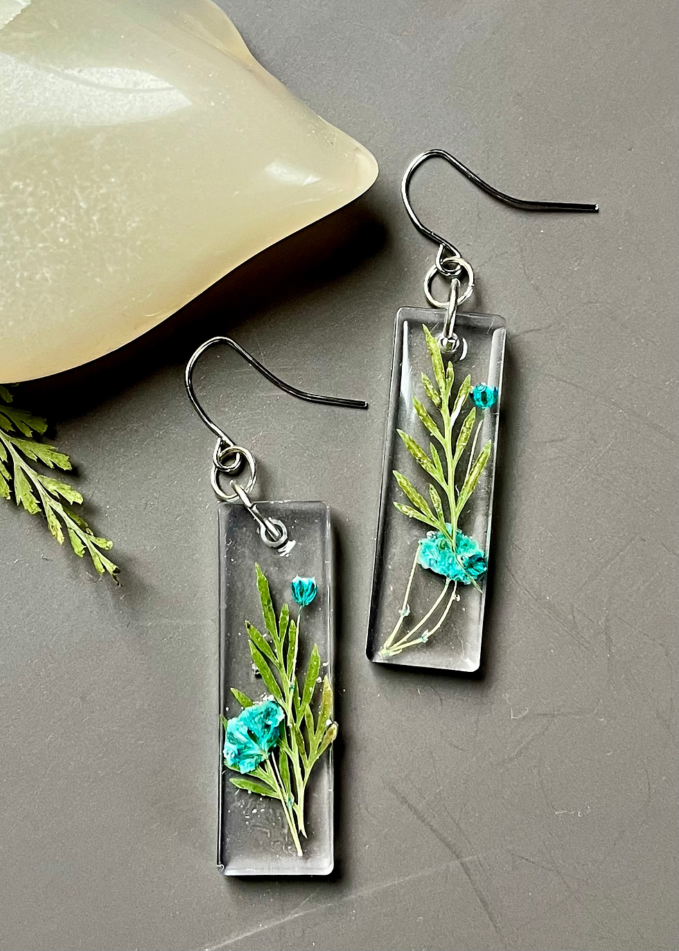 Miniatura: Clear resin earrings with embedded greenery and blue stones, pretty jewellery.