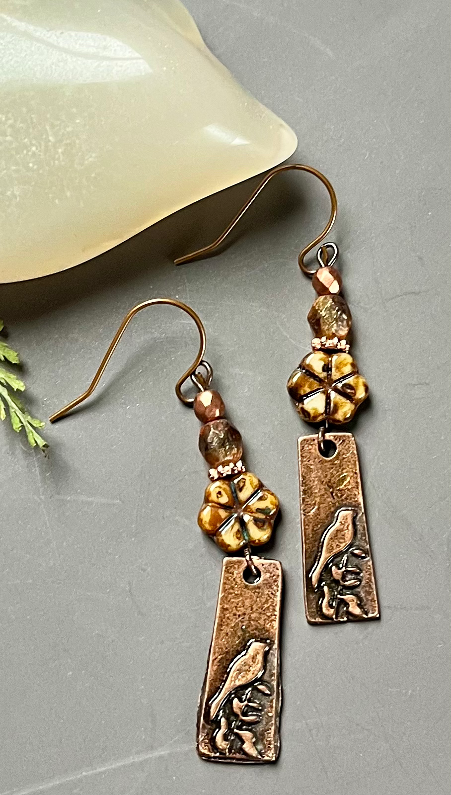 Miniatura: Copper earrings with flower beads and etched bird design, detailed close-up shot.