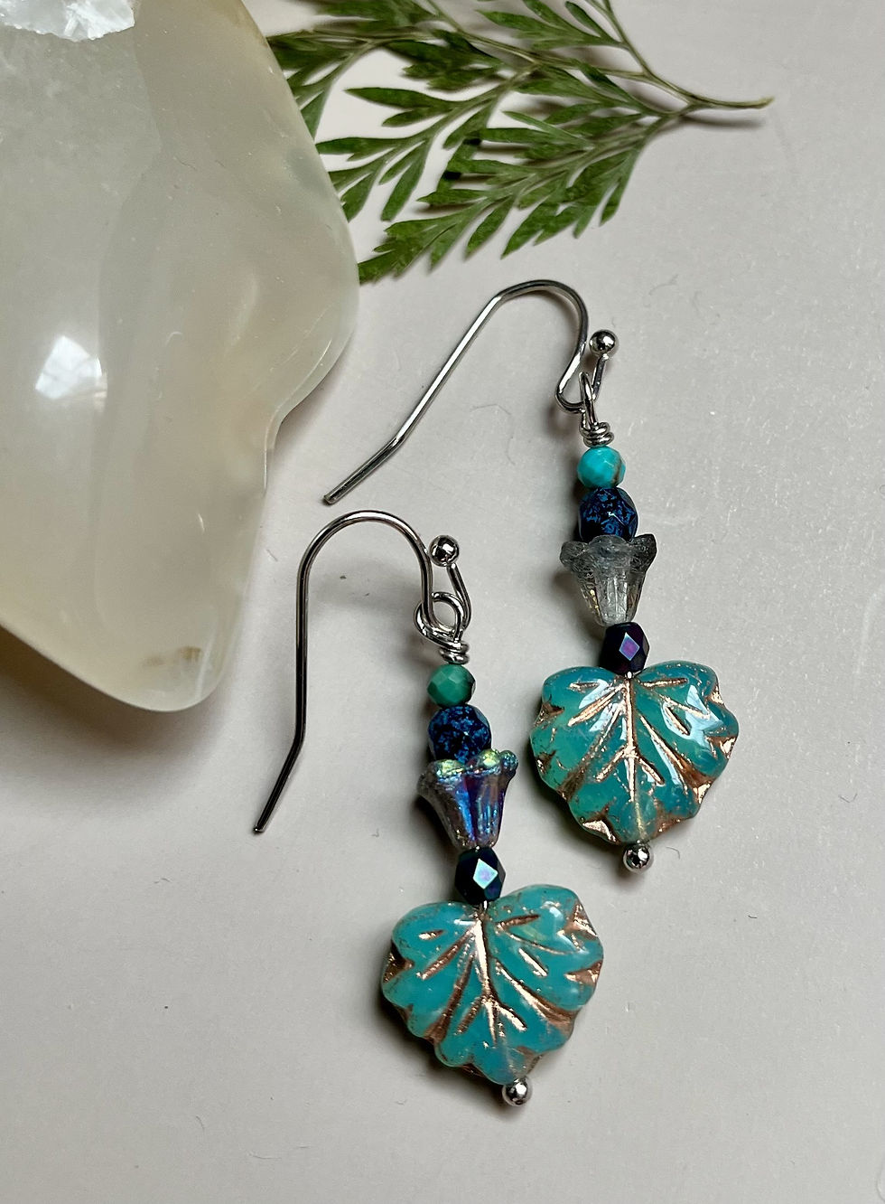 Miniatura: Dangling turquoise leaf earrings with silver hooks and decorative beads close up
