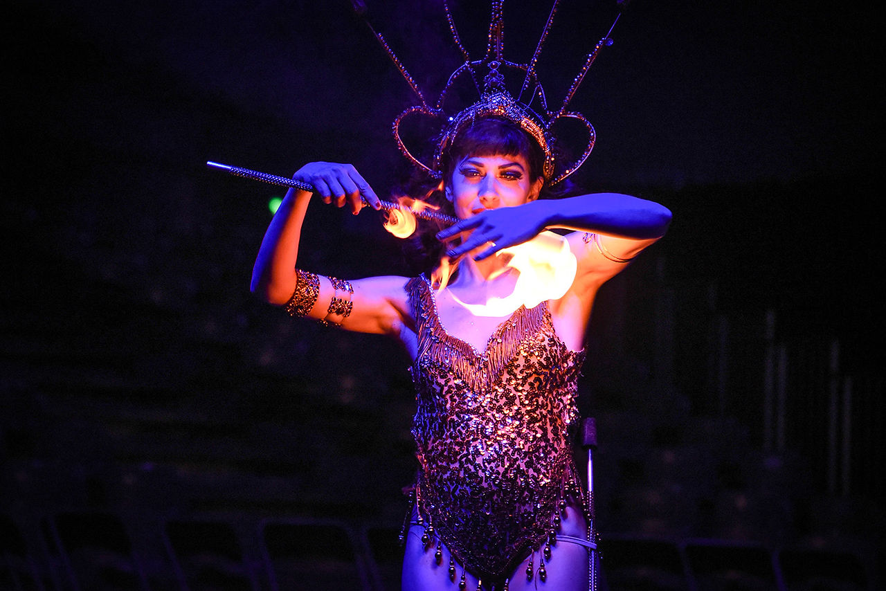 Artiste du Cirque Infernal manipulant du feu sur scène.