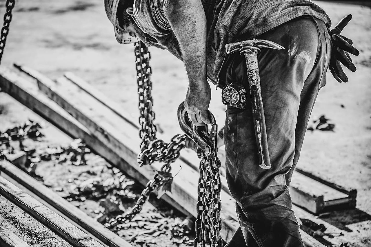 Photographe suivi chantier Toulouse : ouvrier maniant une chaîne
